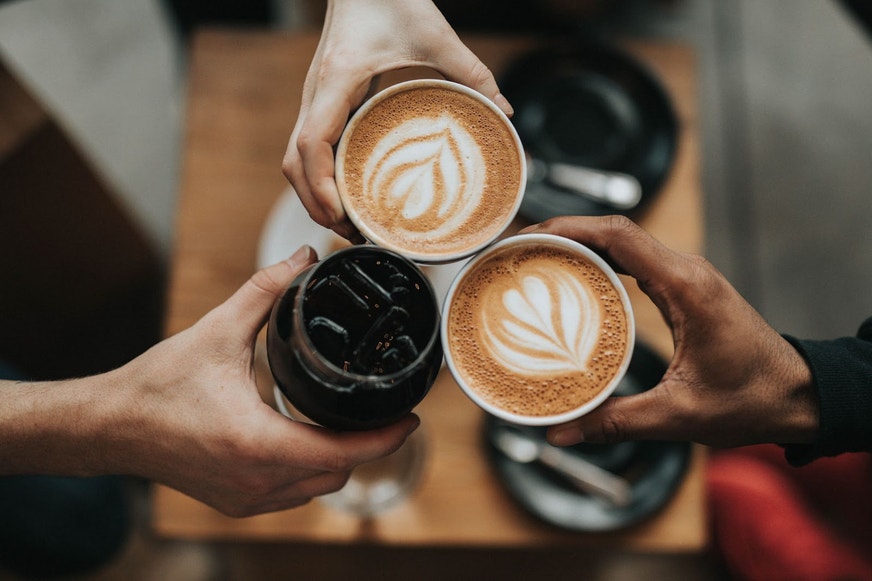 People clinking coffee mugs